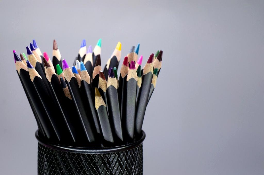 Modern workspace with laptop, notebooks, and coffee cup on wooden desk