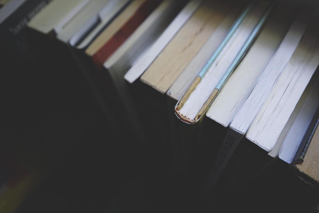 Open books, laptop, and cup of tea on a wooden table